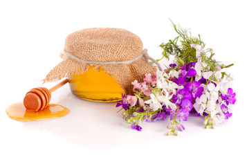 Jar of honey with wildflowers isolated on white background