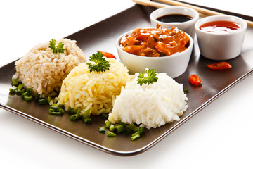 Rice dish with various sauces on white background
