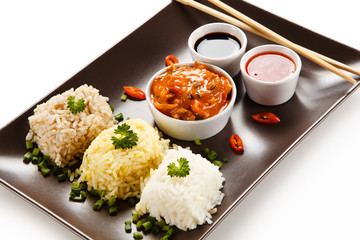 Rice dish with various sauces on white background