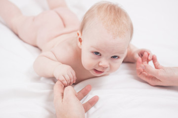 Four month kid holding mother hand, white background.
