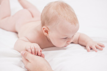 Four month kid holding mother hand, white background.