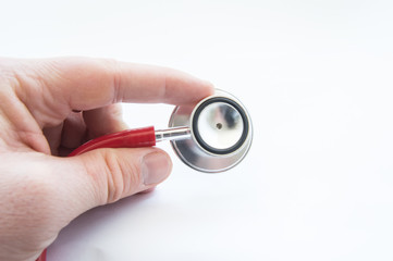 Doctor holds stethoscope, keeping index finger close up on white background. Use in medical practice, display process of auscultation and diagnosis of heart and lung disease in adults and children