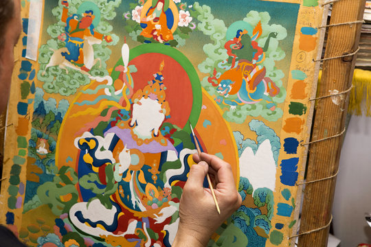 The artist paints a Buddhist icon