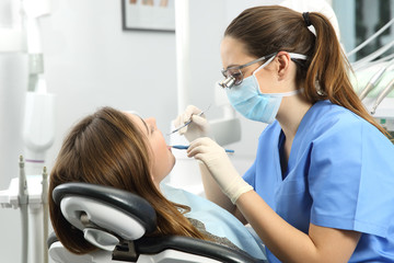 Dentist examining a patient teeth - obrazy, fototapety, plakaty