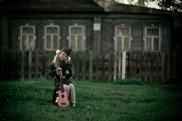 nice little girl in uniform for the holiday of victory with guitar. Russia.