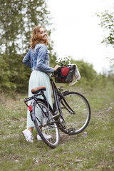 Fototapeta na wymiar Stylish woman with bike in the forest