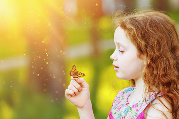 Surprised curly girl with a butterfly on his finger.