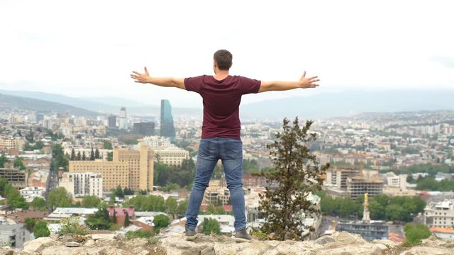 young male on the lookout at the background of Tbilisi