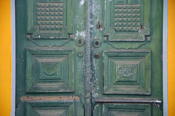 Slightly weathered green double doors in Atalaia.