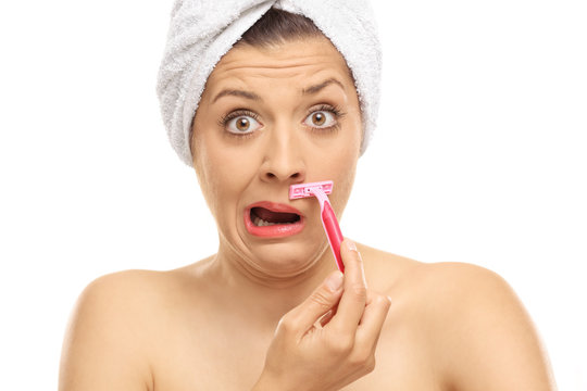 Shocked woman shaving her moustache