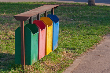Four colors dirty recycle bins or trash can in the park