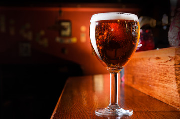 Glass of fresh beer on pub table