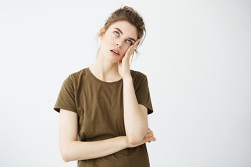 Portrait of displeased bored tired girl with bun over white background.