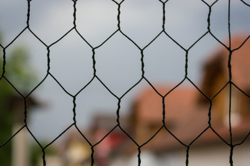 blurred background with gables of houses and a grid in the foreground