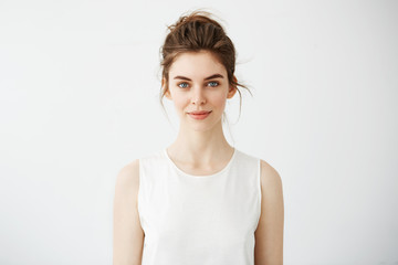 Portrait of young beautiful brunette girl smiling looking at camera over white background.