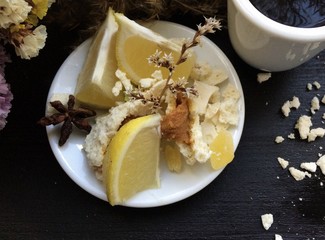 Crashed macaroons on a white plate with coffee and some dry flowers