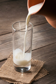 jug of milk with an old country table, a white drink is poured into a glass