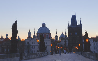 Fototapeta na wymiar Charles bridge, twilight scenery, street lights visible. Prague iconic travel destination, Czech Republic. 