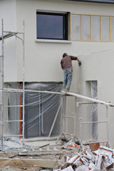 homme r&eacute;alisant cr&eacute;pi sur une fa&ccedil;ade maison
