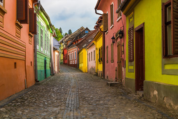 Sighisoara, Romania - lonely street with colorful houses. Discover Romania concept.