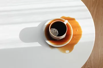 Zelfklevend Fotobehang Spilled coffee on white table © Maya Kruchancova