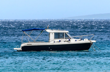 Fototapeta na wymiar Motor boat is moored in high wind on the sea.