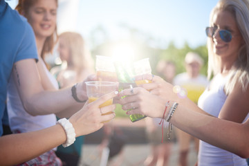 Close up of people cheering with beers at festival party