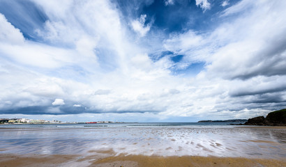 Atlantic sandy beach in Spain with city of Coruna background.