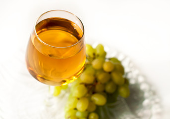 A glass of white wine and a bunch of grapes on a white background. Banner for the restaurant.