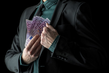 Businessman in black suit holding 500 euro bills