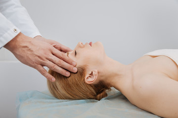 Fototapeta na wymiar Professional distinguished doctor massaging womans head