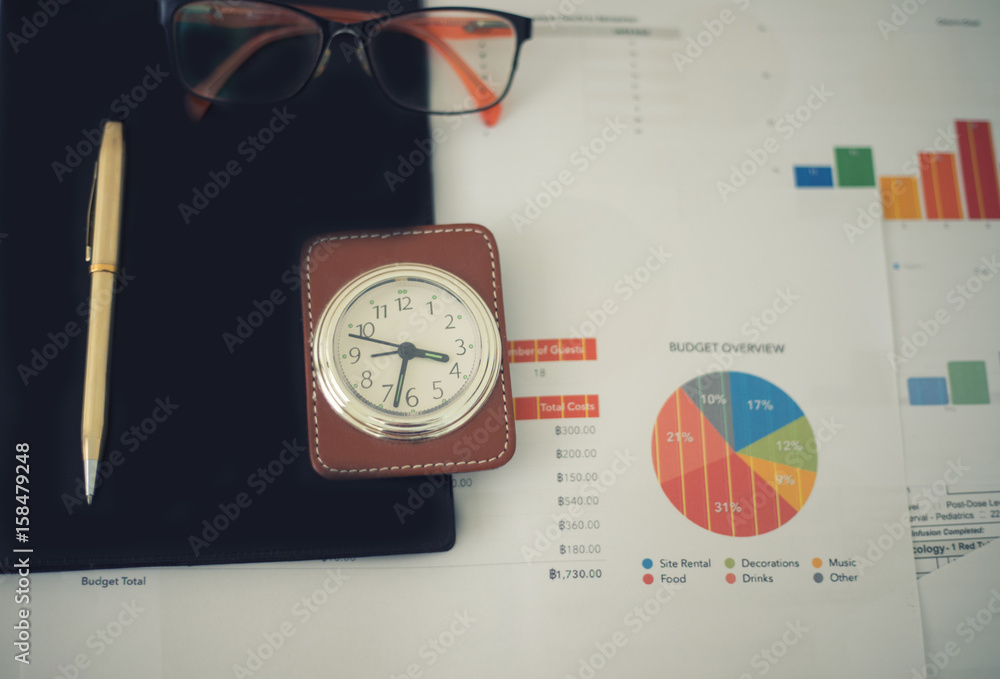 Aufkleber business concept of office working and analysis graphics and clock on table