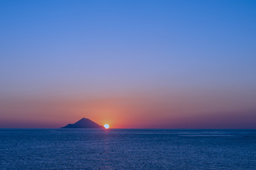 Naklejka na ściany i meble Il sole tramonta dietro l'isola di Filicudi, arcipelago delle Isole Eolie IT