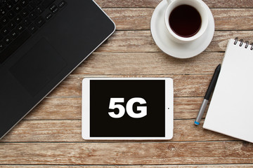 Tablet on desktop with 5g text.