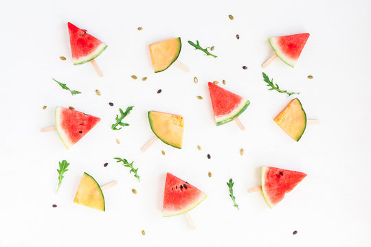 Watermelon popsicle and melon popsicle on white background. Top view, flat lay
