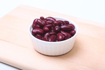 Heap of canned red kidney beans in the sauce in white bowl. vegetarian food. Phaseolus vulgaris.