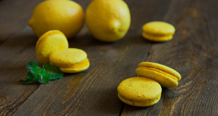 yellow macaroons with lemon on a wooden table
