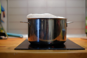 Boil the soup in a saucepan on an induction cooker. Foam rises