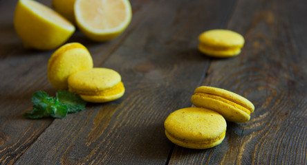 yellow macaroons with lemon on a wooden table