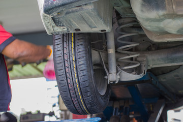 Mechanician changing car wheel in auto repair shop