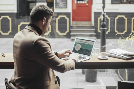 Businessman working on laptop in coffee shop