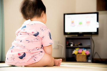畳に座ってテレビを見る赤ちゃん