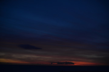 Abstract blurred dawn light shining through dark clouds background. Natural cloudscape skyline
