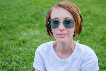 Beautiful Young Woman Outdoors. Enjoy Nature. Healthy Smiling Girl in Green Grass.
