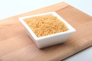 Rice in a bowl on wooden background. ready for cooking.
