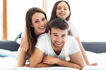 Family of four lying on bed
