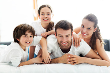 Family of four lying on bed
