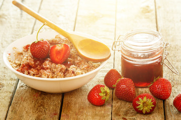 Cooked oatmeal, berries and strawberry jam