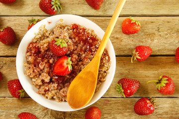 Cooked oatmeal, berries and strawberry jam