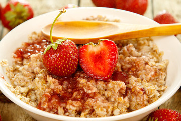 Cooked oatmeal, berries and strawberry jam